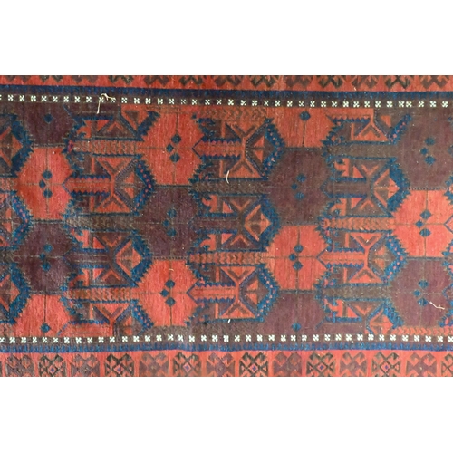 822 - An antique Belouch rug, the red-brown ground with narrow blue bands and wide kelim ends, 202 cm x 10... 