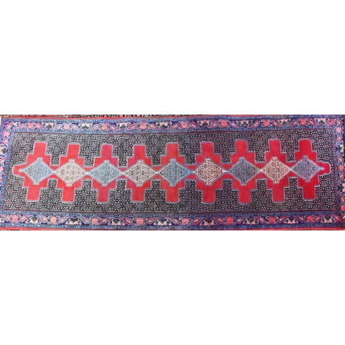 823 - A contemporary North West Persian Senneh runner, the lozenge pole design on red ground, 300 cm x 100... 