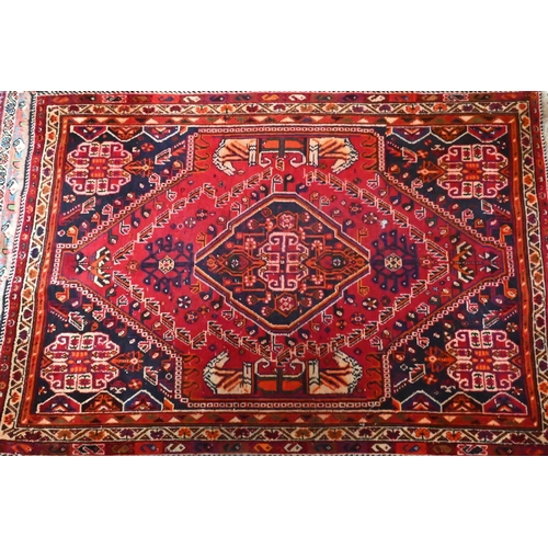 824 - A contemporary South West Persian Shiraz rug, the traditional blue ground centred by a red medallion... 