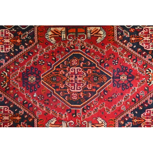 824 - A contemporary South West Persian Shiraz rug, the traditional blue ground centred by a red medallion... 