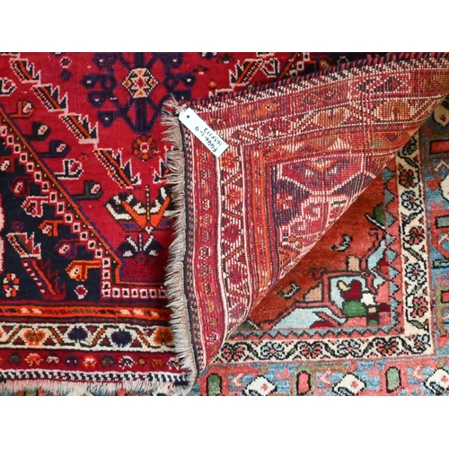 824 - A contemporary South West Persian Shiraz rug, the traditional blue ground centred by a red medallion... 