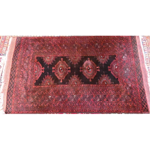 826 - An old Belouch rug, the brown-red ground with stylised lozenge guls, 214 cm x 140 cm