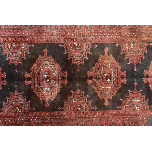 826 - An old Belouch rug, the brown-red ground with stylised lozenge guls, 214 cm x 140 cm