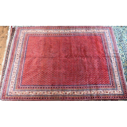 830 - A Persian Arak carpet, the red ground with repeat all-over design of stylised boteh, 294 cm x 218 cm