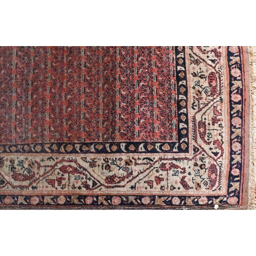 831 - A pair of old close matching Persian carpets, the brown-red ground with stylised designs, of slightl... 