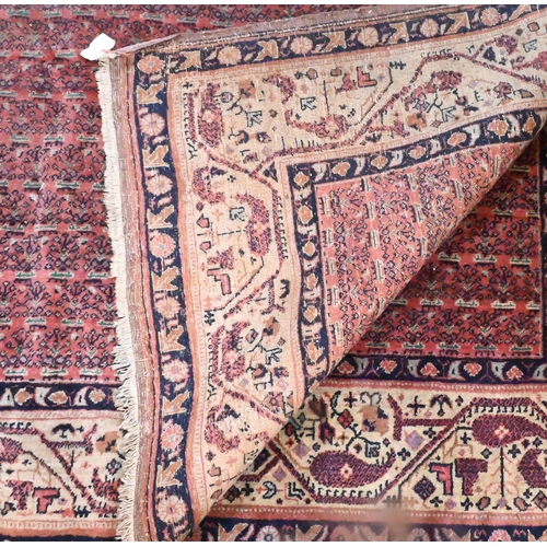 831 - A pair of old close matching Persian carpets, the brown-red ground with stylised designs, of slightl... 