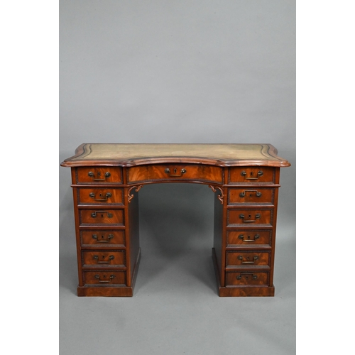 864 - A continental walnut leather topped desk, of inverted serpentine form with an arrangement of thirtee... 