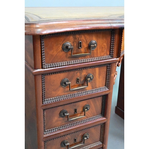 864 - A continental walnut leather topped desk, of inverted serpentine form with an arrangement of thirtee... 