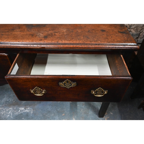 866 - An 18th century oak low dresser, the wide single plank top over three drawers within a shaped apron,... 