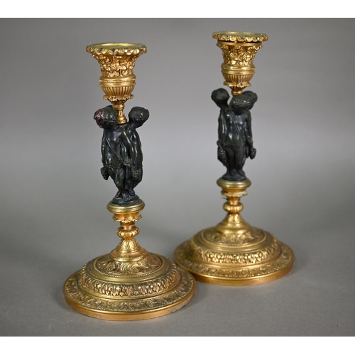 872 - A pair of fine quality neo-classical styled bronze and ormolu candlesticks, centred by a trio of Bac... 