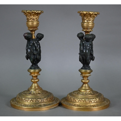 872 - A pair of fine quality neo-classical styled bronze and ormolu candlesticks, centred by a trio of Bac... 