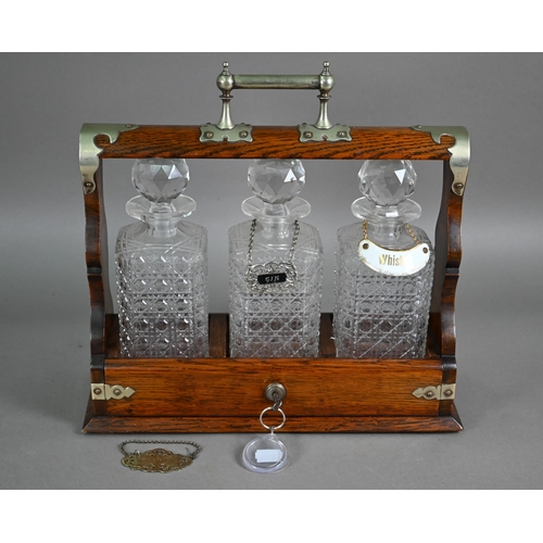 876 - An old silver plate mounted oak three bottle tantalus, 36 cm x 13 cm x 35 cm h (with key)