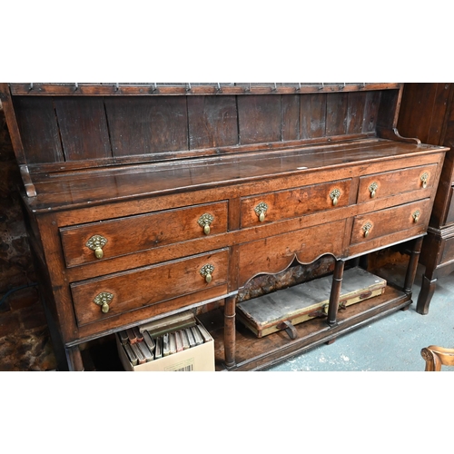 880 - An 18th century oak high dresser, the (associated) two tier rack with stepped canopy, planked back a... 