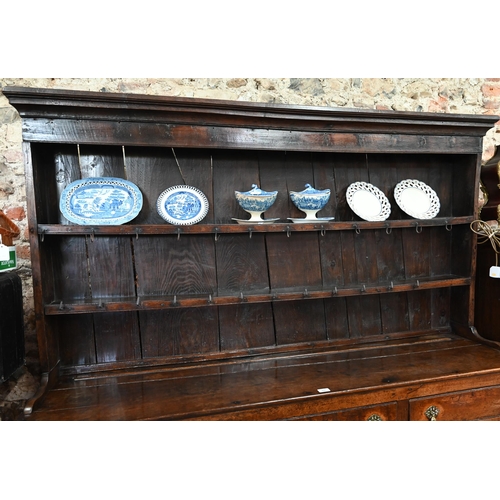 880 - An 18th century oak high dresser, the (associated) two tier rack with stepped canopy, planked back a... 