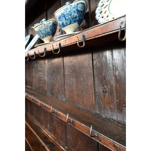 880 - An 18th century oak high dresser, the (associated) two tier rack with stepped canopy, planked back a... 