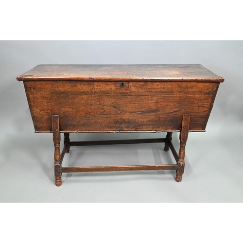 883 - An antique oak dough bin, oak and walnut, the tapered body with single plank top, raised on part tur... 