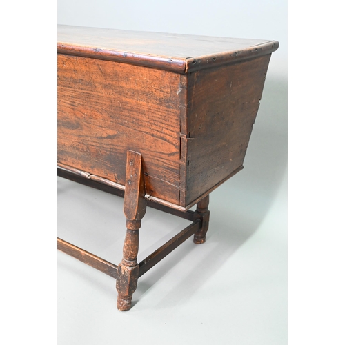 883 - An antique oak dough bin, oak and walnut, the tapered body with single plank top, raised on part tur... 