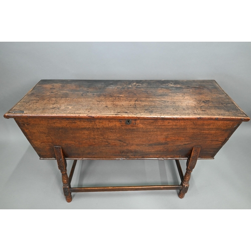 883 - An antique oak dough bin, oak and walnut, the tapered body with single plank top, raised on part tur... 