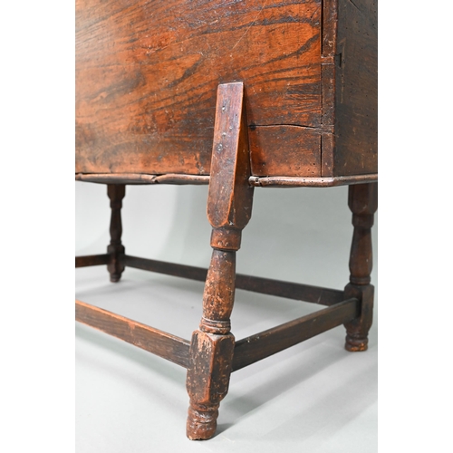 883 - An antique oak dough bin, oak and walnut, the tapered body with single plank top, raised on part tur... 