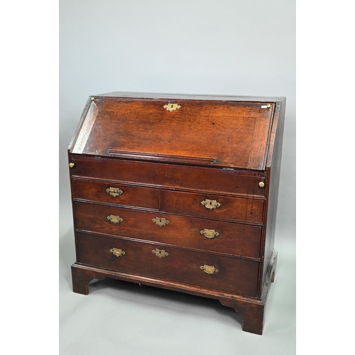 887 - An 18th century oak bureau, the fall enclosing a fitted interior of niches and slide top well over t... 