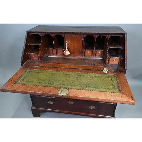 887 - An 18th century oak bureau, the fall enclosing a fitted interior of niches and slide top well over t... 