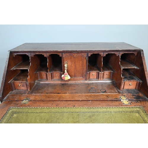 887 - An 18th century oak bureau, the fall enclosing a fitted interior of niches and slide top well over t... 