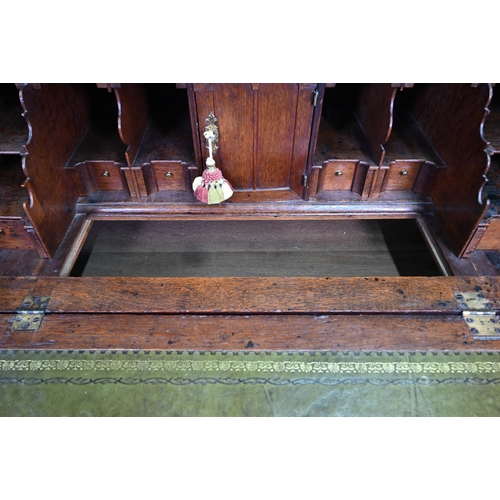 887 - An 18th century oak bureau, the fall enclosing a fitted interior of niches and slide top well over t... 