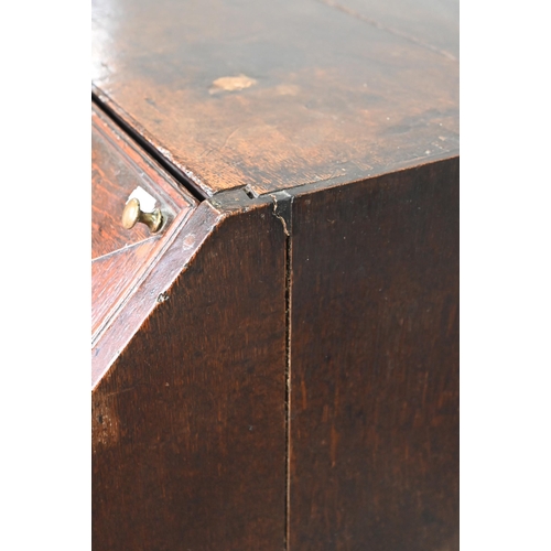 887 - An 18th century oak bureau, the fall enclosing a fitted interior of niches and slide top well over t... 