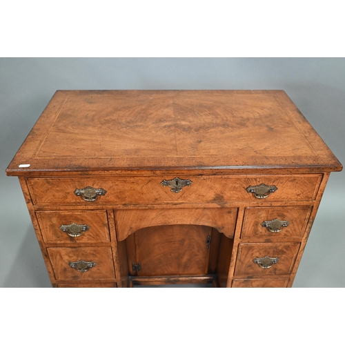 888 - A Georgian style cross-banded walnut kneehole desk, comprising a single long drawer over six short d... 