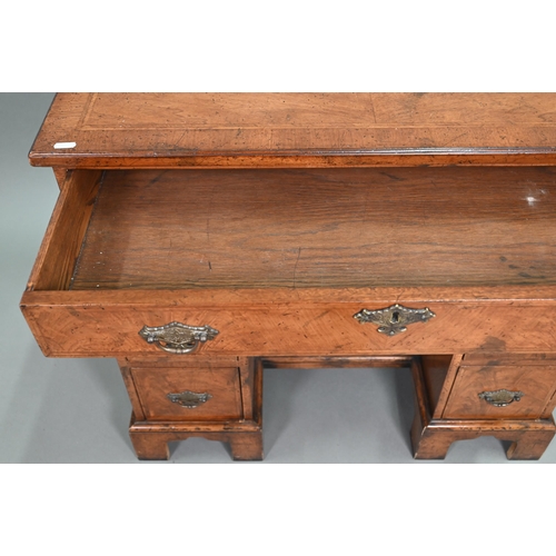 888 - A Georgian style cross-banded walnut kneehole desk, comprising a single long drawer over six short d... 