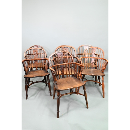 A well matched harlequin set of seven yew and elm seat low splat back Windsor armchairs, 19th century, each with crinoline stretchers, probably Nottinghamshire (7)