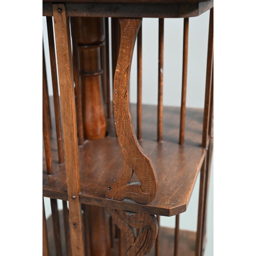 896 - An continental Art Nouveau period floral marquetry inlaid walnut revolving bookcase, raised on a sha... 