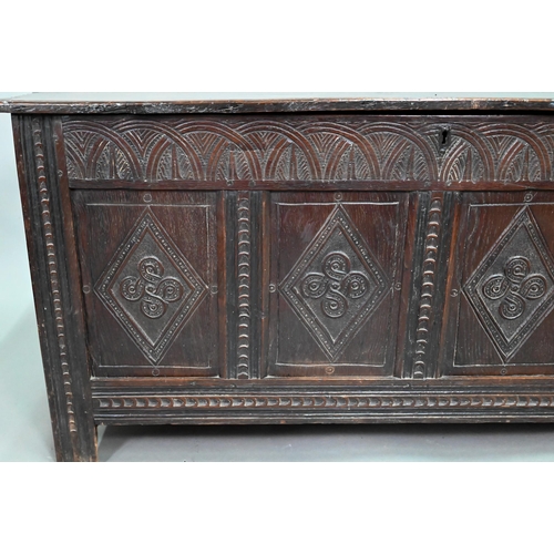 906 - A late 17th century carved oak coffer, the two plank top over a lunette carved frieze and four incis... 