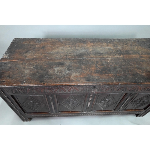 906 - A late 17th century carved oak coffer, the two plank top over a lunette carved frieze and four incis... 