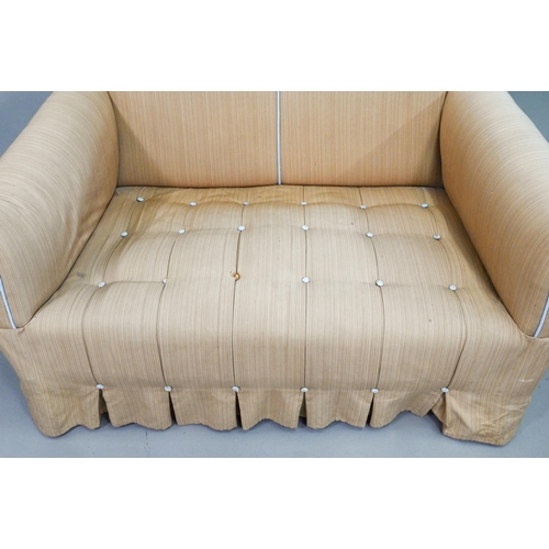 930 - A small country house upholstered two seater sofa, with hump back, raised on walnut legs to castors ... 