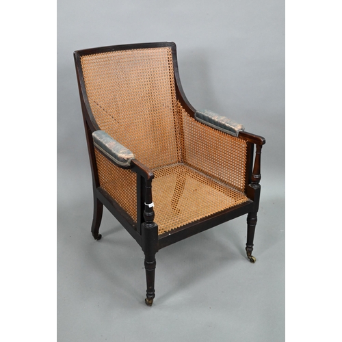 936 - A Victorian mahogany framed bergere panelled library armchair, with traditional loose cushions, rais... 