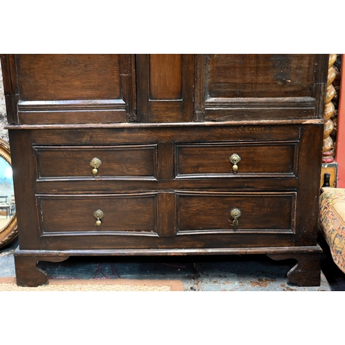 951 - An 18th century and later composed oak two section linen cupboard, the pair of joint framed triple p... 