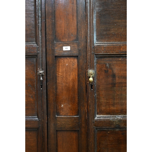 951 - An 18th century and later composed oak two section linen cupboard, the pair of joint framed triple p... 