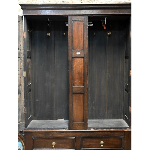 951 - An 18th century and later composed oak two section linen cupboard, the pair of joint framed triple p... 