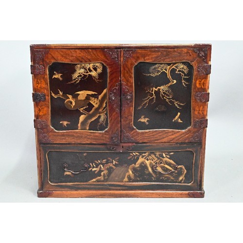 960 - A Japanese part gilt and black lacquered table cabinet, late 19th century, the twin doors enclosing ... 