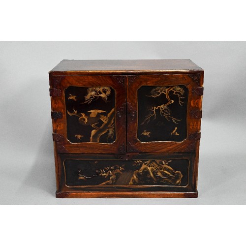 960 - A Japanese part gilt and black lacquered table cabinet, late 19th century, the twin doors enclosing ... 