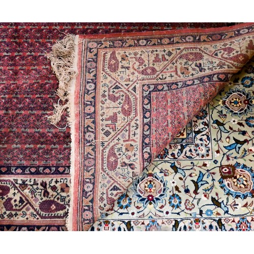 831 - A pair of old close matching Persian carpets, the brown-red ground with stylised designs, of slightl... 