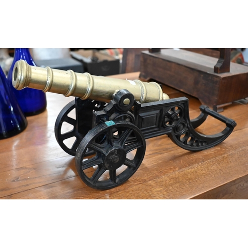 186 - WITHDRAWN A brass model cannon on cast iron stand, 46 cm long