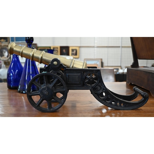 186 - WITHDRAWN A brass model cannon on cast iron stand, 46 cm long