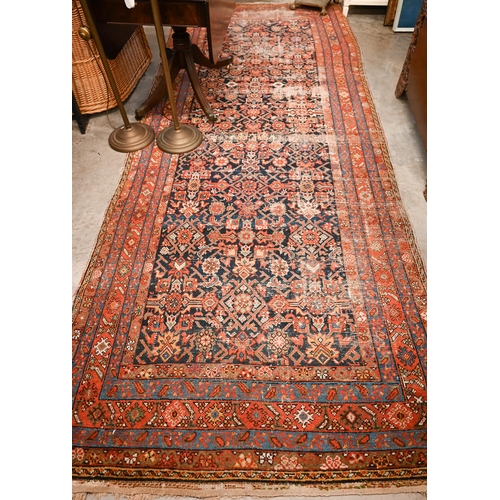 441 - A North West Persian wide runner (very worn), with floral design on navy ground with red/blue border... 