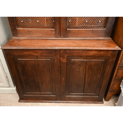 266 - An antique oak cabinet bookcase, the lattice wire panelled doors enclosing shelves and small drawers... 