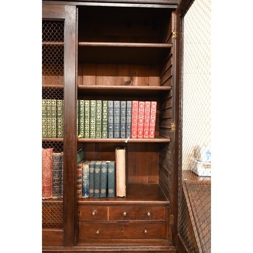 266 - An antique oak cabinet bookcase, the lattice wire panelled doors enclosing shelves and small drawers... 