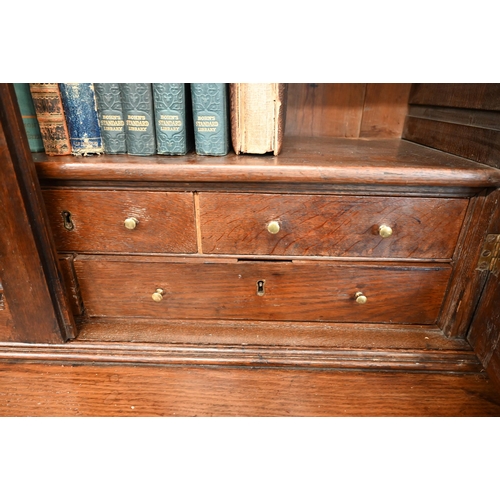 266 - An antique oak cabinet bookcase, the lattice wire panelled doors enclosing shelves and small drawers... 