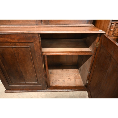 266 - An antique oak cabinet bookcase, the lattice wire panelled doors enclosing shelves and small drawers... 