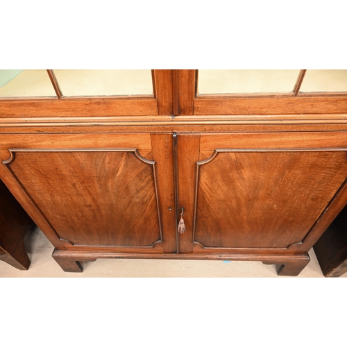 269 - A 19th century mahogany cabinet bookcase with glazed doors over panelled cupboards on bracket feet, ... 